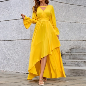 Dettaglio dell'elegante abito giallo con scollo a V, polsini svasati e orlo a balze