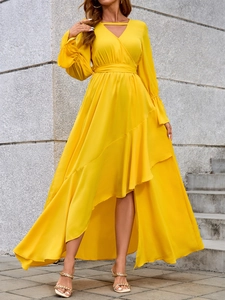 Dettaglio dell'elegante abito lungo giallo con scollo a V, balze e spacco laterale