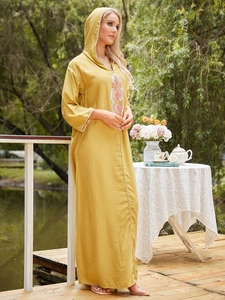 Broderie détaillée sur une robe caftan jaune moutarde avec capuche et glands