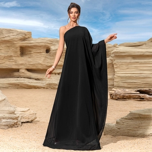 Detail of elegant black one-shoulder maxi dress with flowing chiffon fabric in desert