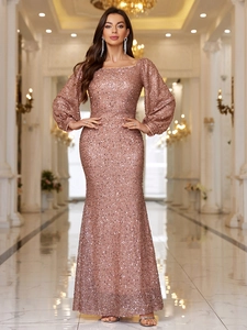 Rose gold sequined evening gown with square neck and puff sleeves in elegant hallway