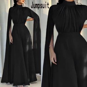 Detail of high neck black jumpsuit with pleated bodice and dramatic cape-style split sleeves