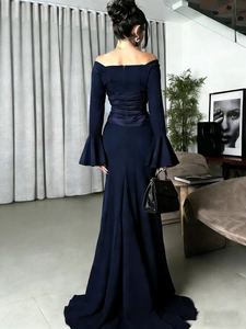 Detailed back view of a navy blue long-sleeve evening gown with flared cuffs and ruching