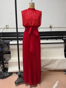 Close-up of red halter neck maxi dress with sequin bodice and pleated skirt details