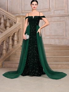 Elegant emerald green sequined evening gown with thin straps and side tulle train detail