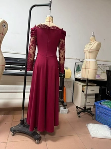 Detail of burgundy evening gown showing off-shoulder lace embroidery and floral sleeves