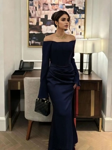 Detail of elegant navy blue off-shoulder evening gown with waist pleats and side slit