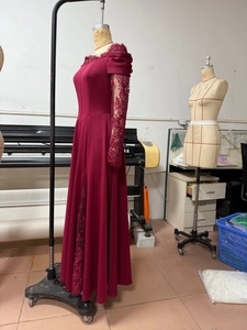 Detailed view of sheer lace floral sleeves and high slit on burgundy evening gown
