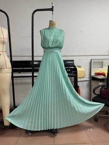 Detail of mint green sleeveless maxi dress with sequined bodice and pleated skirt