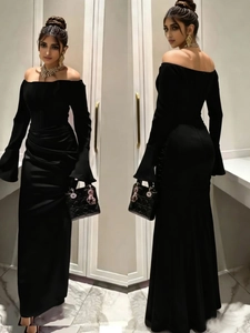 Detailed view of the pleated waist design and sleek satin fabric on a black evening gown