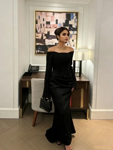 Elegant off-shoulder black satin evening dress featuring long sleeves and a side slit hem