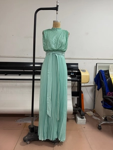 Detail of mint green sequined bodice and pleated maxi dress with tied waist belt