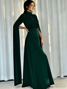 Detail of elegant dark green satin maxi jumpsuit with cape sleeves and pleated waist