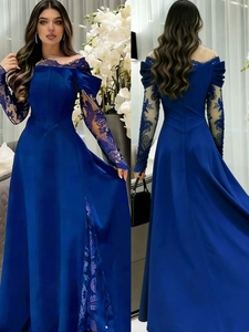 Detailed view of royal blue evening gown featuring intricate lace sleeves and floral patches