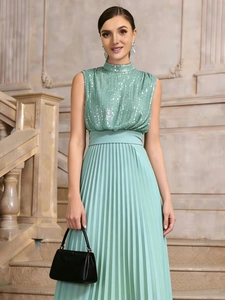 Detail of mint green sleeveless dress featuring shimmering sequins and pleated long skirt