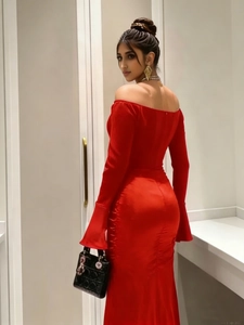 Detail of red off-shoulder evening dress with long flare sleeves and split hem design