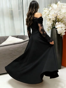 Rear view of an elegant black evening dress with lace sleeves and a full flared skirt