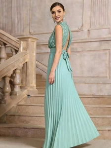 Detail of sequined backless bodice with bow tie on mint green pleated maxi dress