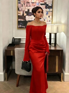 Detail of red off-shoulder satin evening gown with elegant waist pleats and fishtail hem