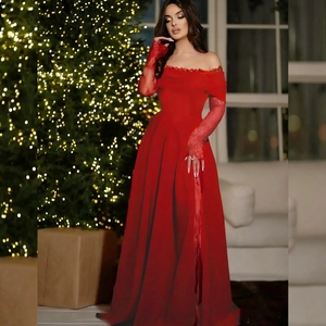 Détail de la robe de soirée rouge épaules dénudées avec manches dentelle et fente haute