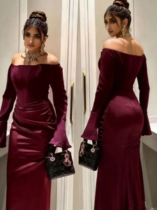 Detail view of burgundy off-shoulder evening dress with trumpet sleeves and back slit hem