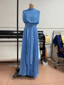 Detail of blue sequined sleeveless bodice and pleated maxi dress on a mannequin