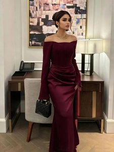 Detail of burgundy satin off-shoulder dress featuring ruched waist and slit hem design