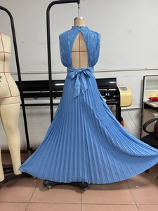Detail of the large blue bow and open back design on a sequin pleated maxi dress