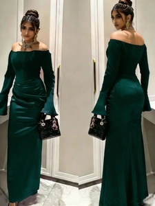 Detailed view of dark green off-shoulder evening gown with elegant flared sleeves