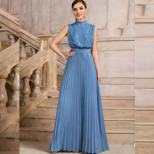 Detail of blue sequined bodice and pleated maxi dress against an elegant stone staircase