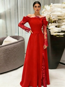 Close-up of elegant burgundy evening gown with lace sleeves and side slit detail