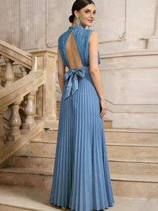 Detail of light blue pleated maxi dress with elegant large bow on the high waistline