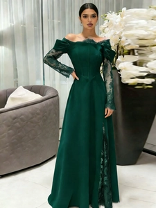 Close-up of elegant lace sleeves and high side slit on dark green evening gown