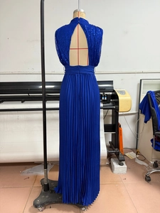 Detail of royal blue sequined halter neck dress with pleated floor-length skirt