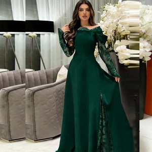 Close-up of emerald green evening dress with lace sleeves and high side slit detail