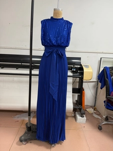 Detailed view of royal blue sequined bodice with large bow and pleated maxi skirt