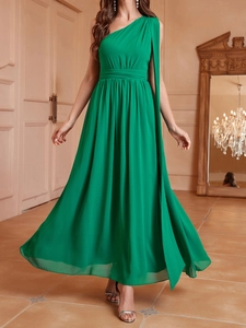 Détail d'une robe en mousseline vert vif à une épaule avec cape élégante et taille plissée