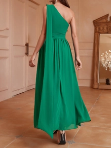 Détail d'une robe de soirée asymétrique vert émeraude en mousseline avec plis à la taille