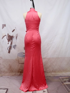 Detail view of coral pink satin evening gown featuring a halter neck and fishtail hem