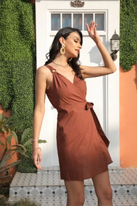 Detailed view of brown sleeveless wrap dress with a deep V-neck and stylish waist tie