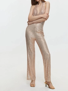 Detail eines Pailletten-Jumpsuits in Roségold mit tiefem V-Ausschnitt und weitem Bein
