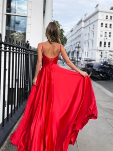 Detailed back view of red satin gown showing the elegant cross lace-up open back design