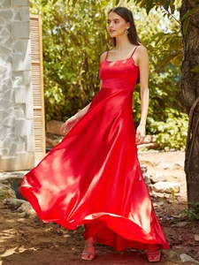 Detail of red satin evening gown with delicate straps and flowing A-line silhouette