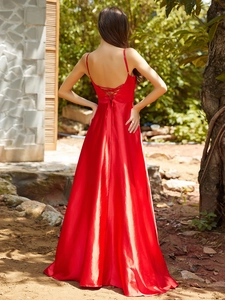 Detail of red satin maxi dress featuring an elegant backless design with crisscross straps
