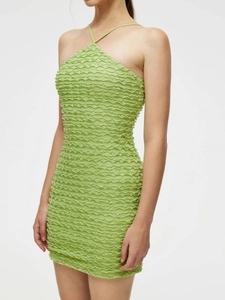 Close-up of grass green popcorn fabric texture on a bodycon halter neck dress