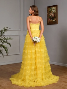 Detailed view of yellow tiered tulle gown with lace trim and elegant open back design