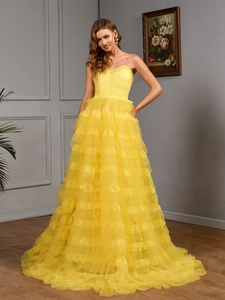 Detail of yellow tiered tulle gown featuring intricate pleated bodice and lace trim edges