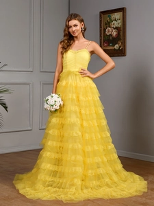 Macro view of layered bright yellow tulle ruffles on an elegant sleeveless evening dress