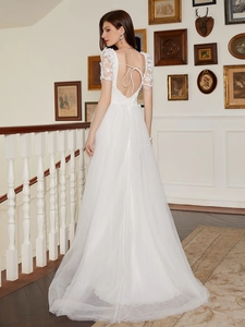 Elegant white French-style lace wedding dress with open back and a full tulle skirt