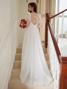 Elegant backless white lace wedding dress with intricate embroidery and layered mesh skirt